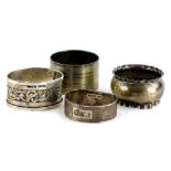 A collection of four silver napkin rings, to include one with a floral scroll border, 2¼oz.
