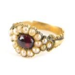 A Victorian memorial ring, set with cabochon garnet stone, surrounded by seed pearls,