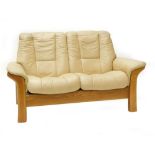 A cream leather Stressless two seater sofa, with beech frame, 102cm wide. (AF)