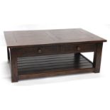 A rustic oak coffee table, the planked top with cleated ends, above two frieze drawers, the base
