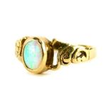A 9ct gold opal dress ring, with central oval cut opal, in a rub over setting, with rococo style