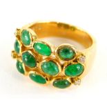An emerald and diamond set dress ring, with three row design of cabachon emeralds, with four tiny
