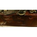 A mahogany low unit or sideboard, with three drawers and three panelled doors on a plinth, glass