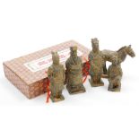 A set of terracotta figures in Han dynasty style, depicting four men and a horse, in presentation