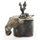An Indian bronze elephant's head inkwell, of quatrelobe form, the hinged lid surmounted with a bird,