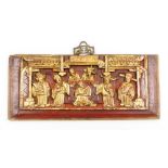 A Chinese carved and red lacquered wooden panel, depicting priests at an alter, gilt highlights