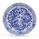 A Chinese blue and white plate, decorated with a pair of four clawed dragons chasing the flaming