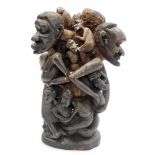 A heavily carved African tribal group, formed as many entwined figures, on a shaped base, 39cm high.