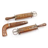 Three Indian teak knife & scissor sets, two on brass supports and pistol grip dagger, 29cm and