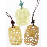 Three pendants, comprising a jade style pendant, of shaped form decorated with fish with a pierced