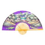 An Oriental fan, the purple material painted with a village scene, and water lilies, 46cm high, 75cm