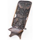 Tribal Art. An African carved hardwood seat, the back with panels of fish, figures and a bird,