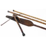A collection of African tribal weaponry, cross bow with turned handle and figure head with metal