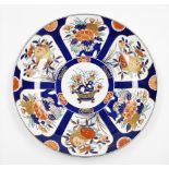 A Japanese Imari charger with basket of flowers, surrounded by panels of floral bouquets on a blue