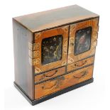 A Japanese Meiji period parquetry and lacquer table cabinet, with two doors opening to reveal six