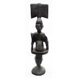 A heavily carved ebonised African tribal totem style figure, formed as two figures with elaborate