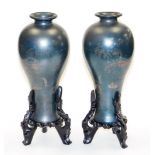 A pair of late 20thC Japanese lacquer vases, each of a dark blue colour with figures boating on a