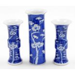 A Chinese porcelain prunus vase trio, comprising two gu shaped vases and a cylinder vase of