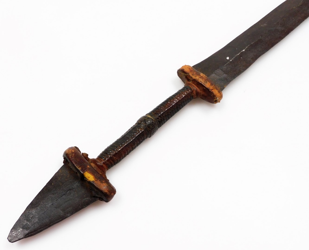 An African tribal knife, with tapering blade, turned handle with metal arrowhead pommel, 68cm wide. - Image 2 of 5