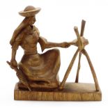 A heavily carved figure group, of a lady in flowing robes holding double ended knife, on plain base,