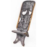 Tribal Art. An African carved hardwood seat, the back with pierced decoration of birds and fishes,