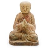 A Chinese carved wood statue of a monk, in flowing robes, at prayer in seated pose, possibly