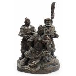 A Chinese bronzed spelter figural group, of a seated bearded general with two attendants on a rock