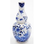 A Chinese porcelain blue and white double gourd vase, decorated with a butterfly above flowers, four