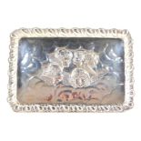 An Edward VII rectangular silver dressing table tray, embossed with cherub's heads within a