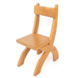 A light oak X frame chair, with solid seat.