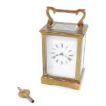 A brass early 20thC carriage clock, enamel dial bearing Roman numerals, the case of conventional