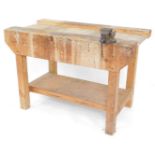 A pine work bench with a vice, and under tier, 84cm high, 122cm wide, 62.5cm deep.