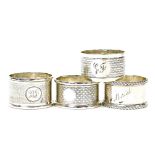 Four various silver napkin rings, comprising a napkin ring with engine turned decoration and bearing
