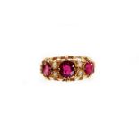 A ruby and diamond set gypsy ring, set with three oval rubies, and four tiny diamonds, each in claw