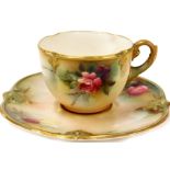 A Royal Worcester blush ivory cup and saucer, the tea cup decorated with a pink rose, gilt decoratio