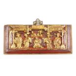 A Chinese carved and red lacquered wooden panel, depicting priests at an alter, gilt highlights and