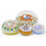 Four Millefiori type paperweights, each of varying size and design, with multicoloured canes and twi