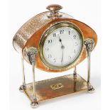 An Art & Crafts electroplate on copper mantel clock by A E Jones, the hammered elliptical head