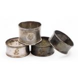 Four silver napkin rings, two bearing the initial F, another unmarked and another with engine turned