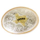 A Texas rodeo belt buckle, the front with embossed design of flowers and scrolls, with a raised Texa