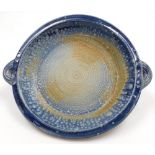 A Studio pottery bowl, signed P Brambly, in a blue and brown mottle design with two handles, 43cm wi