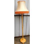 A beech effect standard lamp, with shade.