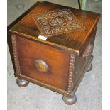 A carved oak log box, with carved top on bun feet, 37cm high, 34cm wide, 34cm deep.