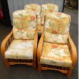 A cane conservatory suite, comprising two seater sofa and two chairs, each with floral upholstered