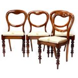 A set of four Victorian mahogany balloon back dining chairs, each with a padded seat and turned