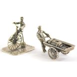 Two Dutch miniature figures, one of a man riding a Penny Farthing, and another of a man pushing a