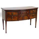 A George III mahogany bow fronted sideboard, the top with an ebony strung border and a gadrooned