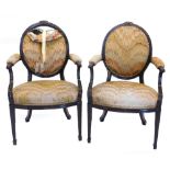 A pair of continental mahogany open armchairs in French style, each with an oval back, carved with