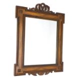 A continental mahogany wall mirror, with a pierced ribbon carved crest, above a rectangular plate,