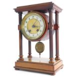A late 19th/early 20thC French walnut portico type clock, with a moulded top, reeded pillars